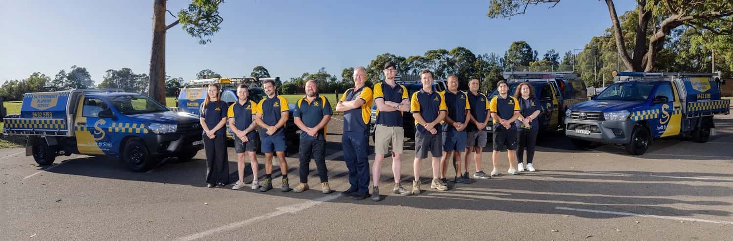 Scott & Sons plumbers in navy and yellow uniforms beside their service vehicles